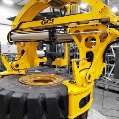 Overhead mount GCI manipulator lifting 3,000 lb Caterpillar tires of varying sizes