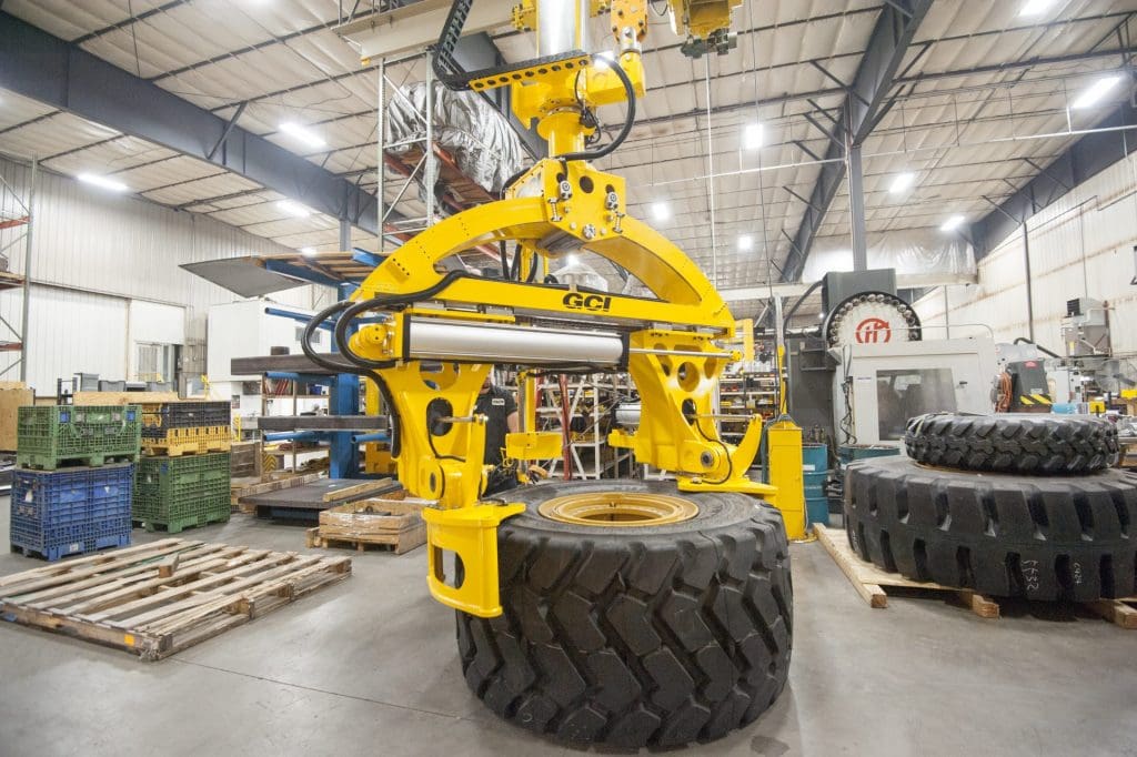 Overhead mount GCI manipulator lifting 3,000 lb Caterpillar tires of varying sizes