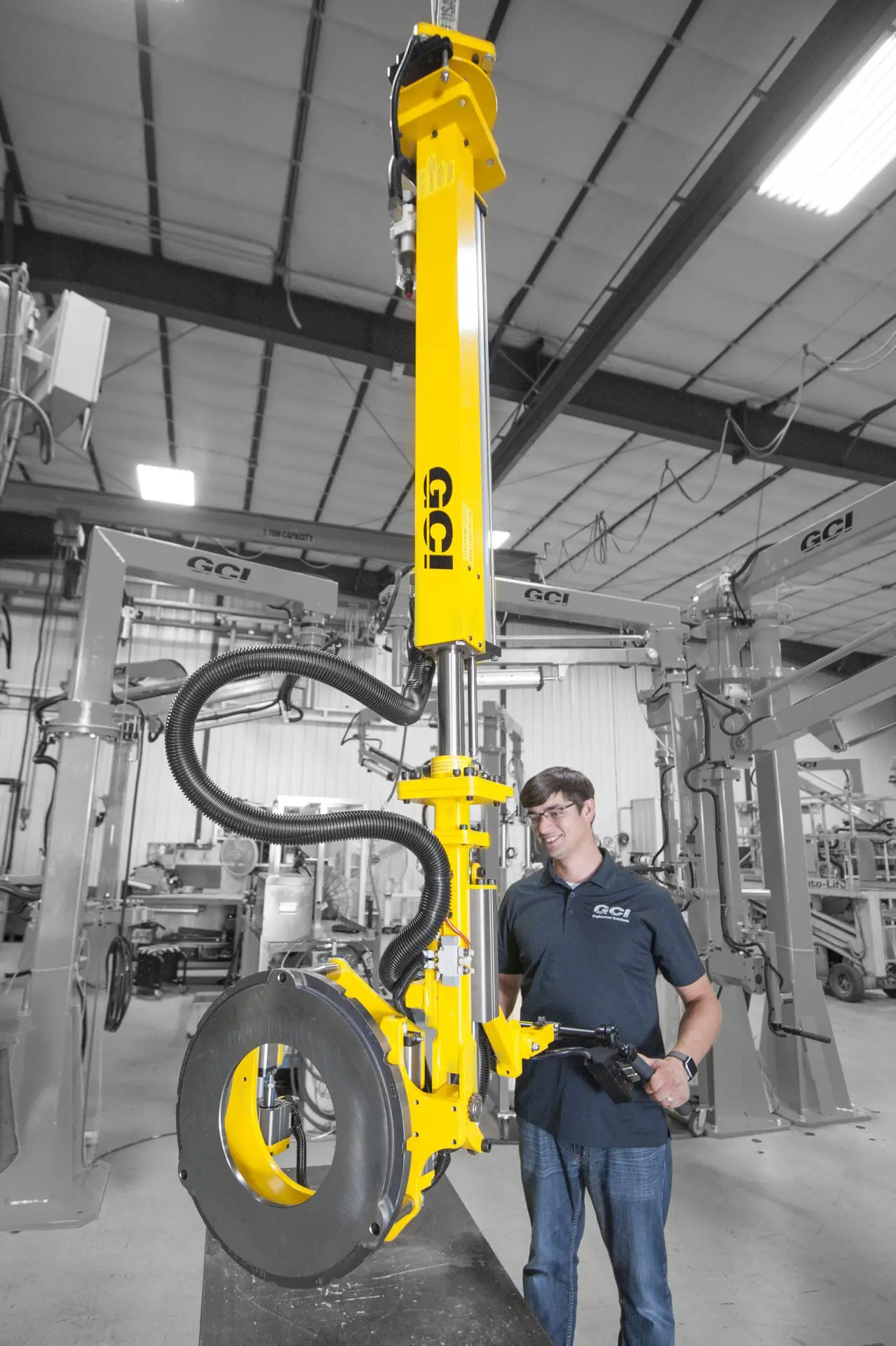 Operator lifting a backing plate with an overhead lift cylinder manipulator