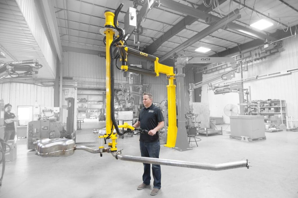 Operator lifts heavy exhaust with a GCI industrial manipulator arm