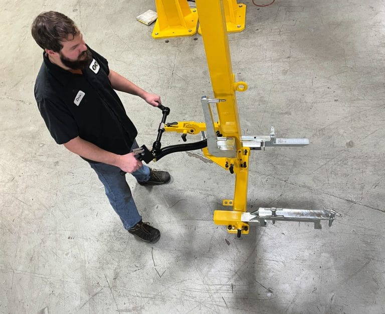Operator at the controls of this heavy material handling manipulator arm for an engine assembly line