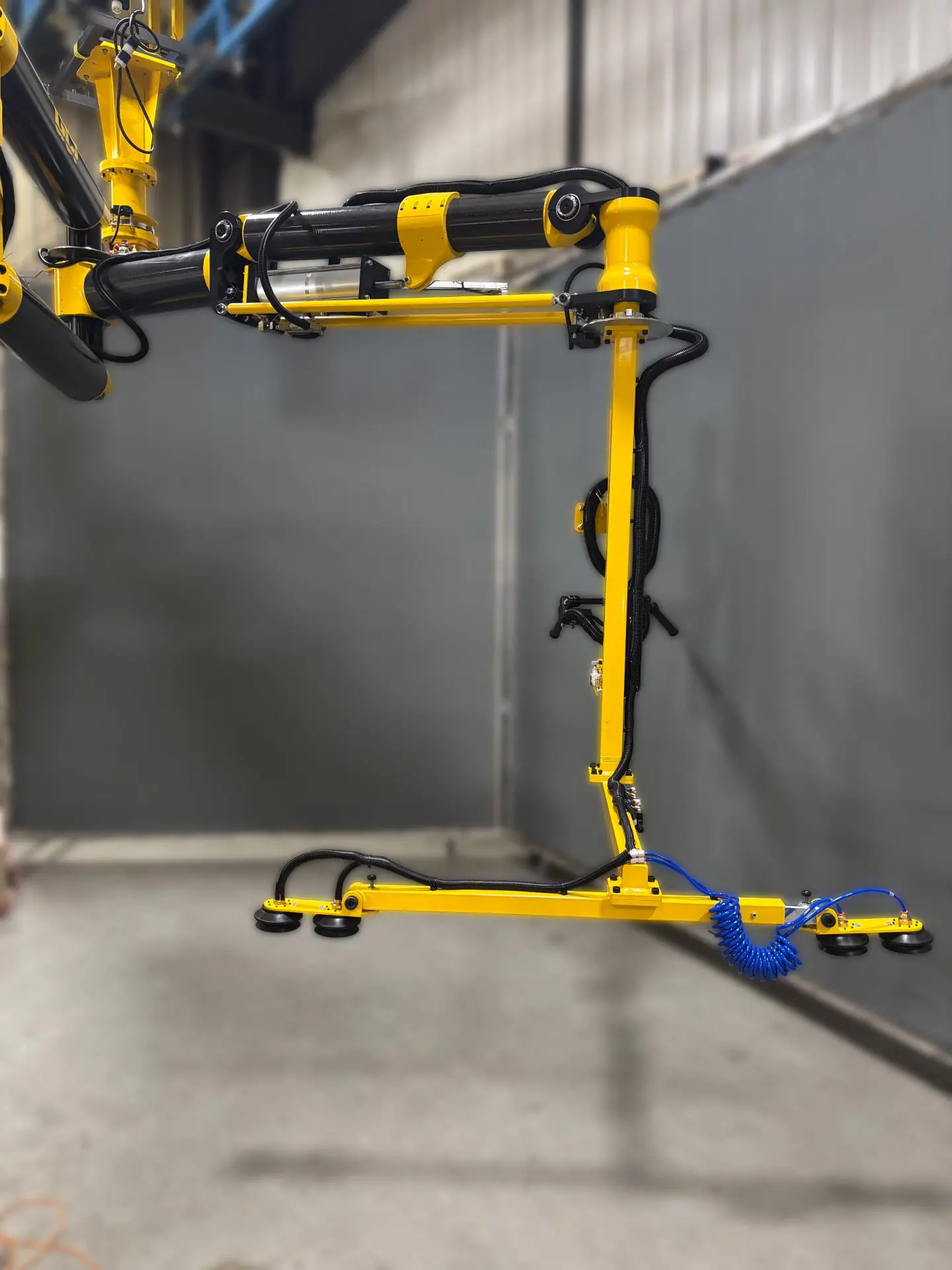 Carbon fiber manipulator arm with a vacuum cup gripper for sheet metal material handling process
